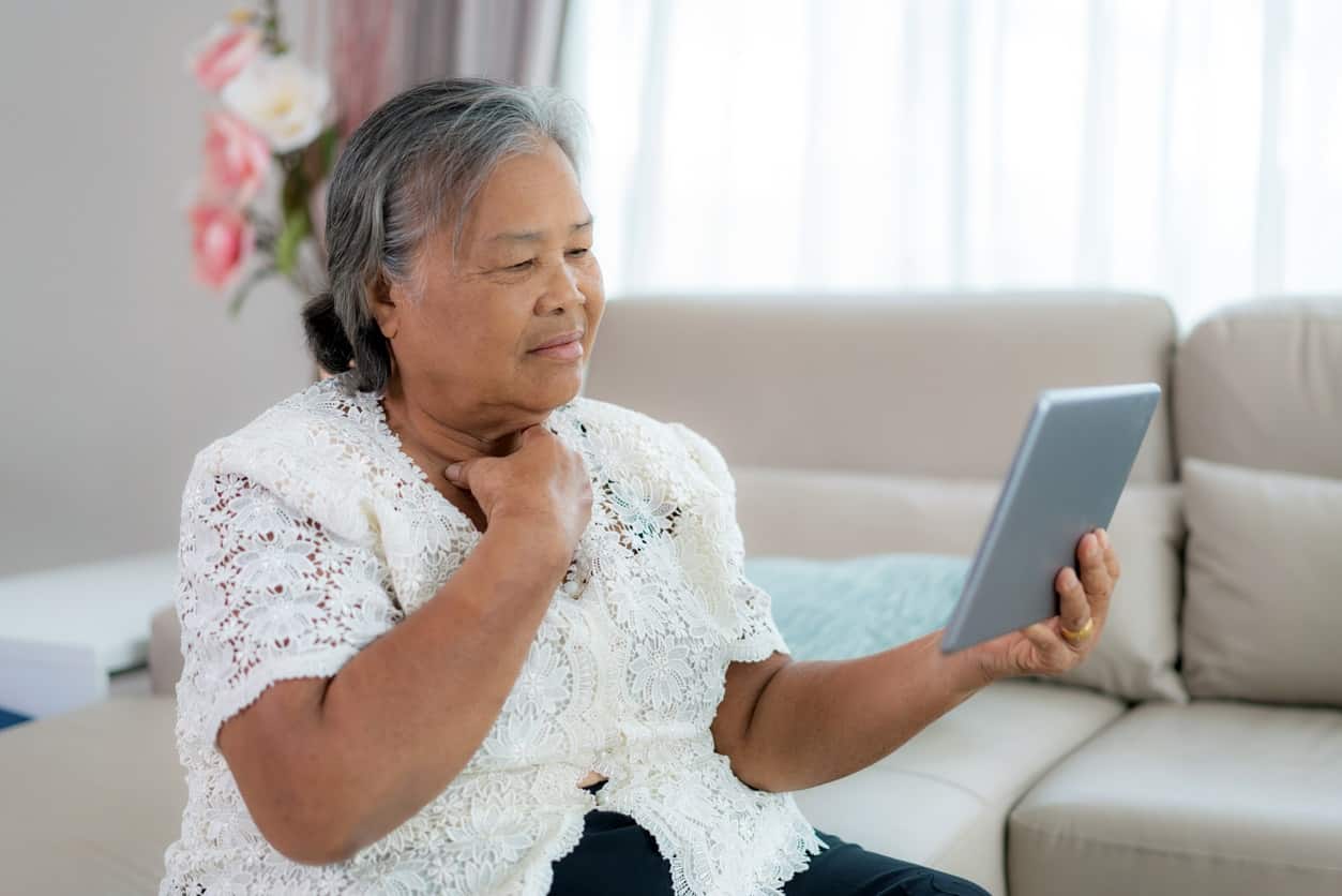 Asian Elderly woman making video call with her doctor with her feeling sore  - Regional One Health