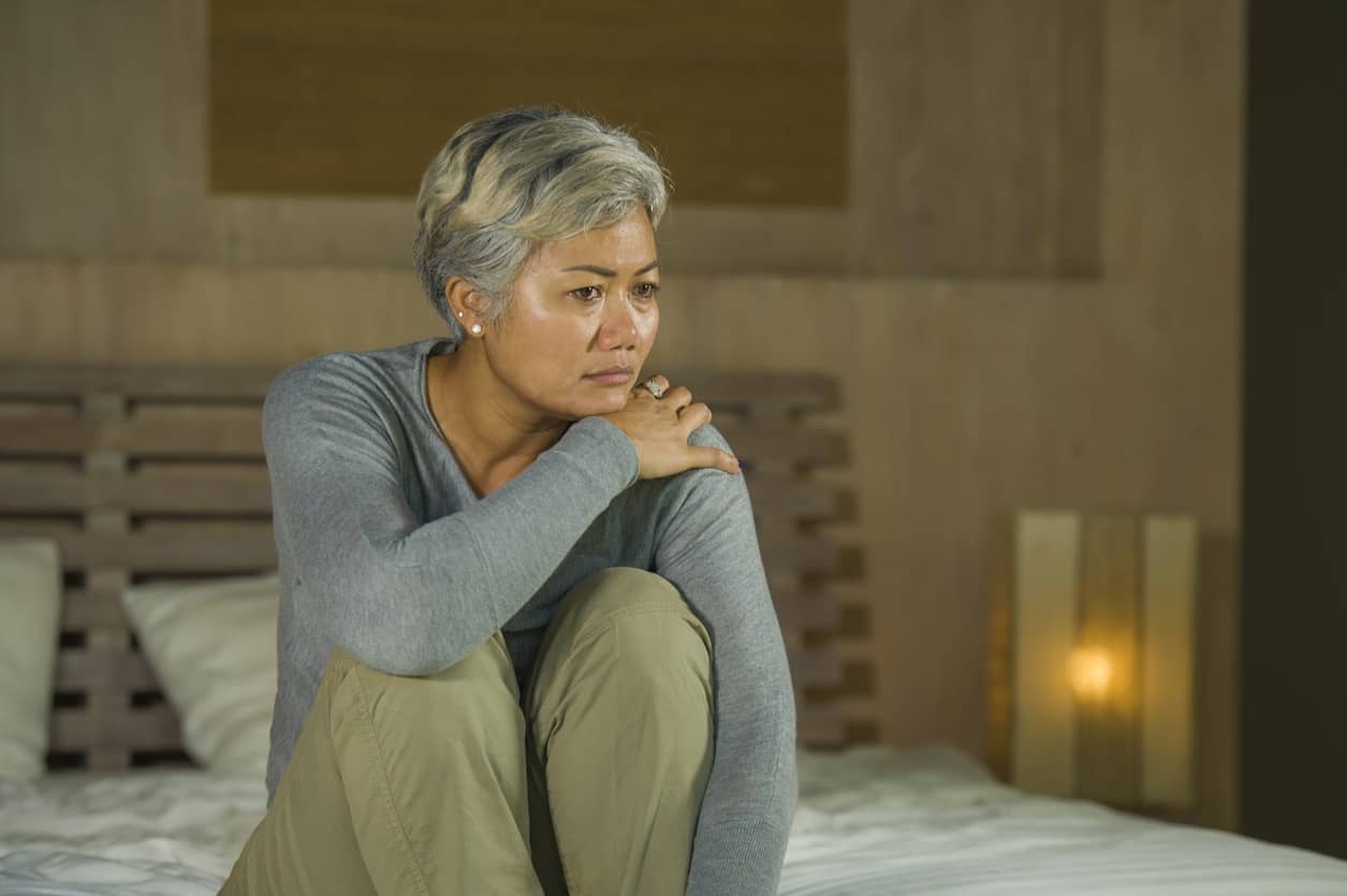 depressed and sad grey hair mature woman crying lonely sitting on bed -  Regional One Health